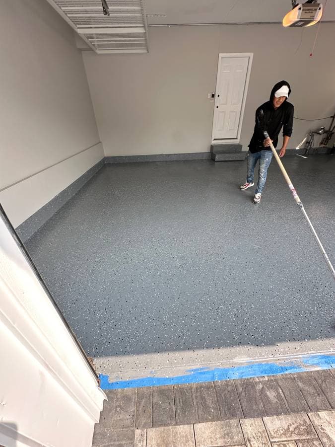picture of a painter with a construction company painting a garage floor in long island new york