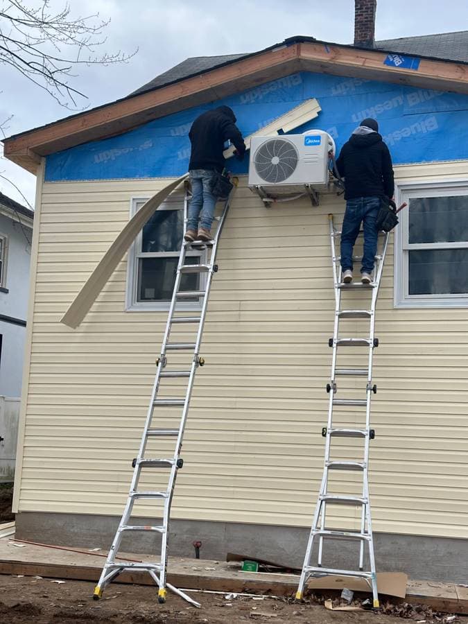construction and painting company in long island new york putting up siding on a residential home